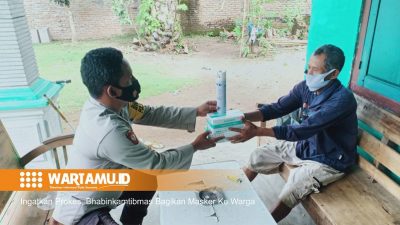 Ingatkan Prokes, Bhabinkamtibmas Bagikan Masker Ke Warga